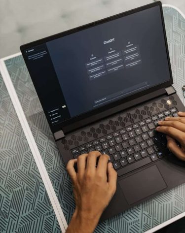 Person typing on a laptop with ChatGPT displayed, showcasing modern technology use.